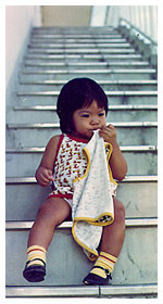 2-year-old April sitting on the steps outside the family's apartment in Japan, where April's father was based.